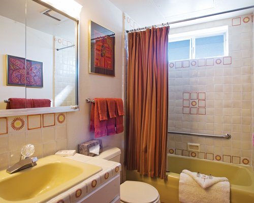 A bathroom with a bathtub and single sink vanity.