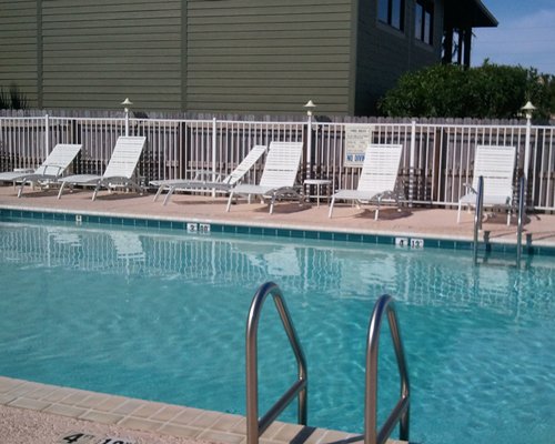 An outdoor swimming pool with chaise lounge chairs.