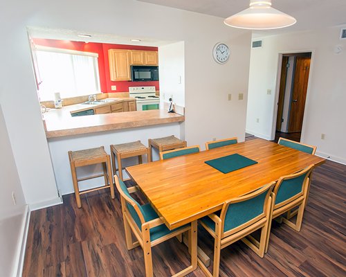 A well furnished dining area alongside kitchen with a breakfast bar.