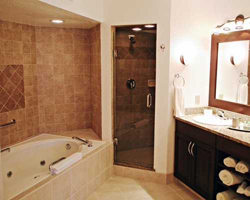 A bathroom with stand up shower bathtub and single sink vanity.