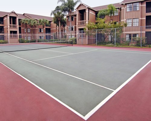 An outdoor tennis court alongside resort units.