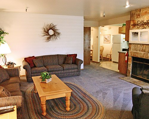 An open plan living room with fireplace and kitchen.