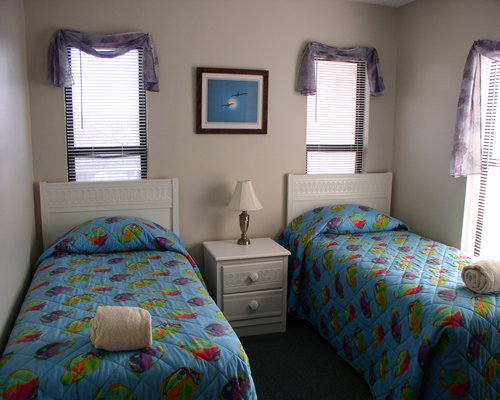 A well furnished bedroom with two twin beds and an outside view.
