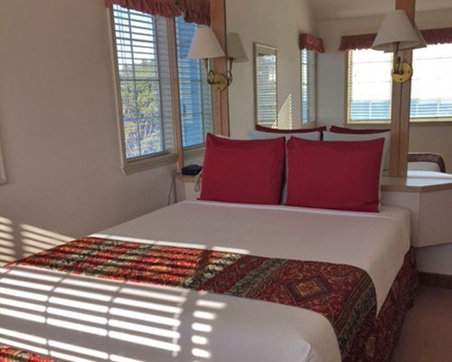 A well furnished bedroom with a queen bed and an outside view.