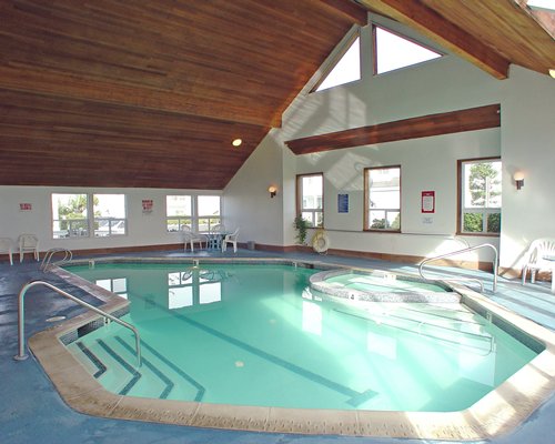 An indoor recreation area with patio furniture pull out sofas television and an outside view.