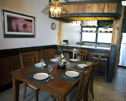 A well furnished dining area alongside kitchen with a breakfast bar.