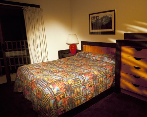 A well furnished bedroom with a queen bed and outside view.