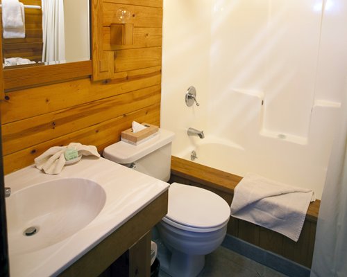 A bathroom with a bathtub and single sink vanity.