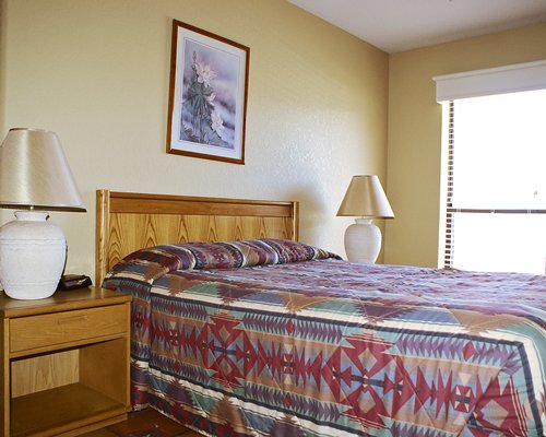 A well furnished bedroom with a queen bed and an outside view.