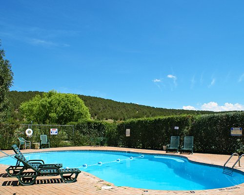 An outdoor swimming pool with chaise lounge chairs.