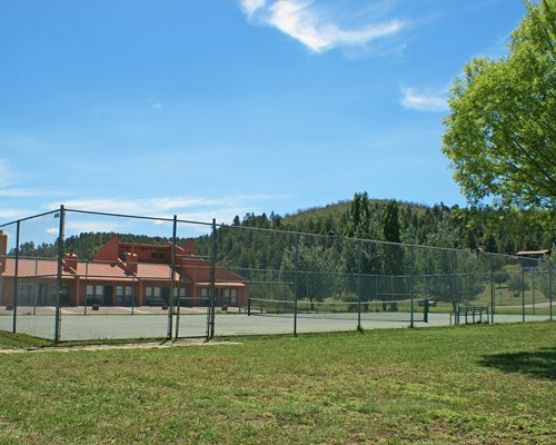 An outdoor view of the tennis court alongside the resort.