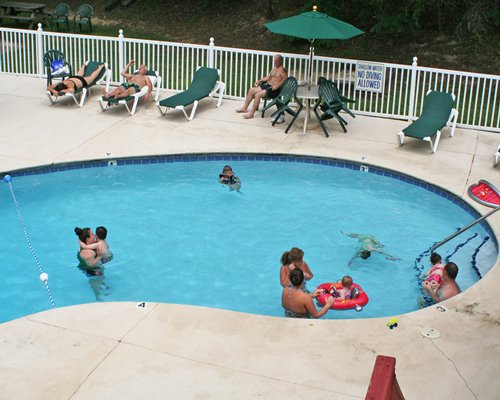 An outdoor swimming pool with chaise lounge chairs and patio furniture.
