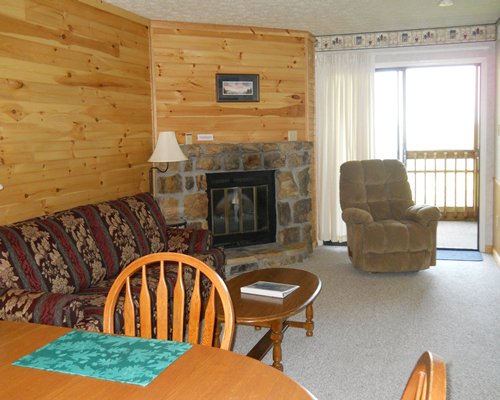 An open plan living and dining area with a fireplace and balcony.