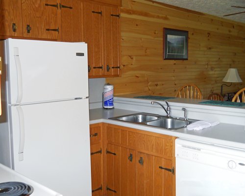 A kitchen with a refrigerator and double sink.