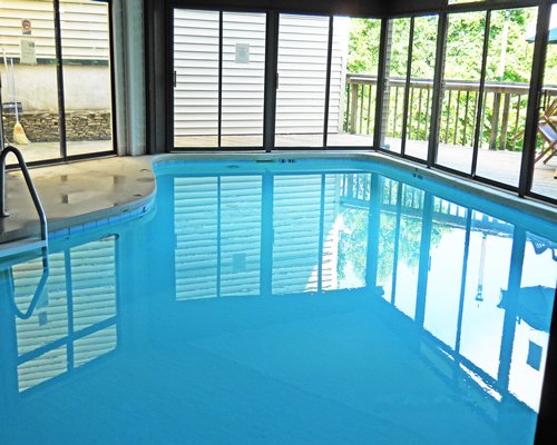 An indoor swimming pool with an outside view.