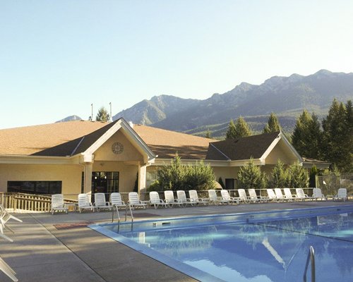 An outdoor swimming pool with chaise lounge chairs alongside the resort unit.