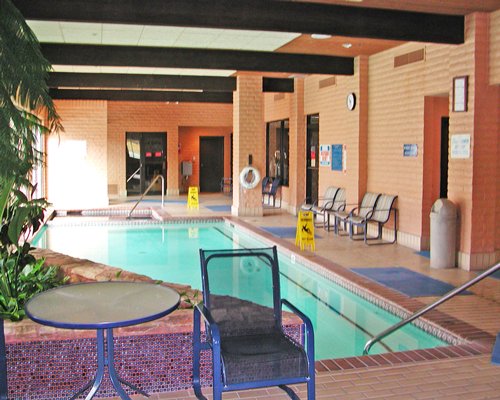 An indoor swimming pool with patio furniture.