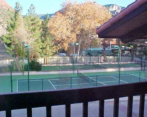 Balcony view of an outdoor tennis court.