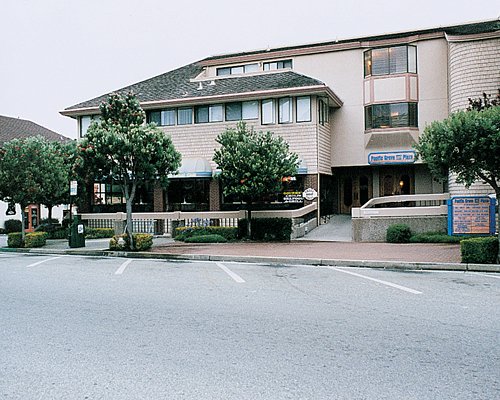 A street view of the Pacific Grove Plaza with parking lot.