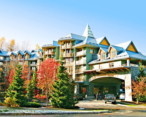An exterior view of multi story resort units alongside trees.