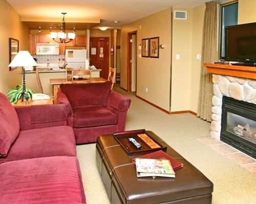 A well furnished living room with an open plan kitchen and dining area.