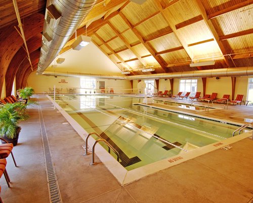 Indoor swimming pool with chaise lounge chairs.
