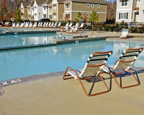 Outdoor swimming pool with chaise lounge chairs alongside the units.