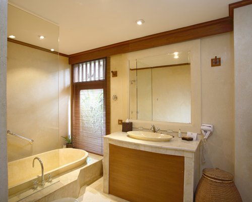 A bathroom with a bathtub and single sink vanity.