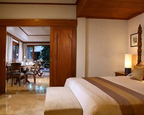 A well furnished bedroom with king bed and dining area.