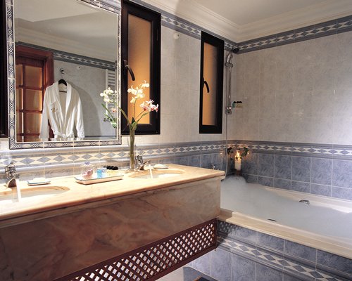 A bathroom with shower bathtub and double sink vanity.