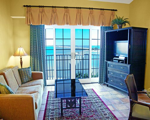 A well furnished living room with a television balcony and bay view.
