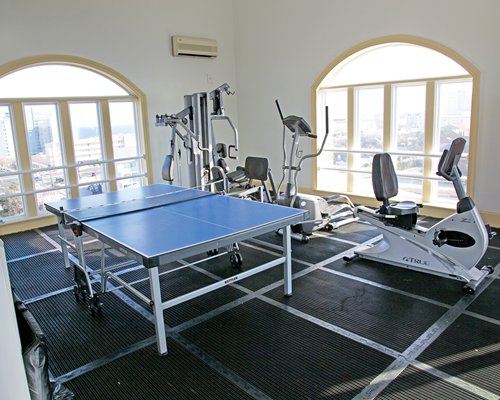 A well equipped fitness center with a ping pong table.