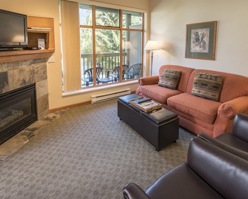 A well furnished living room with a television fireplace and balcony.