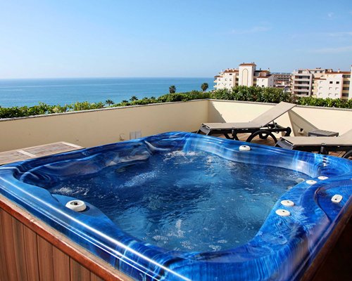 An outdoor hot tub with chaise lounge chairs.