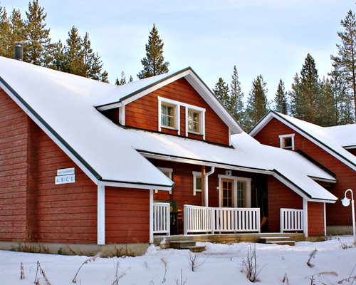 An exterior view of the resort units with pine trees in the snow.
