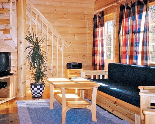 A well furnished living room with a television and double pull out sofa alongside a stairway.
