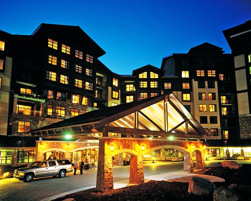 An exterior view of multi story resort units at night.