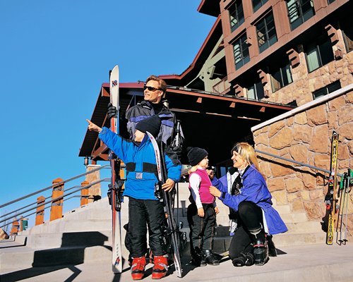A family with snowboards alongside the resort.