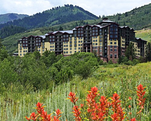 An exterior view of the resort unit alongside trees and hills.