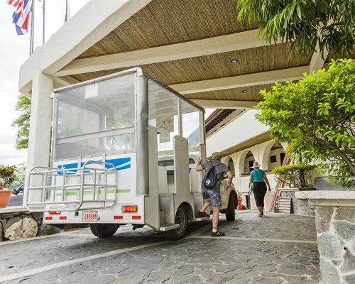 Entrance to Villas Sol Hotel and Beach Resort with a van and landscaping.
