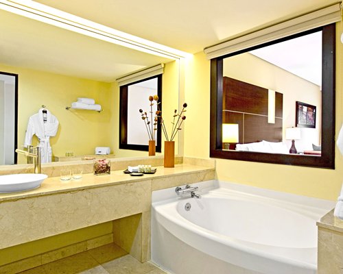 A bathroom with bathtub shower and single sink vanity.