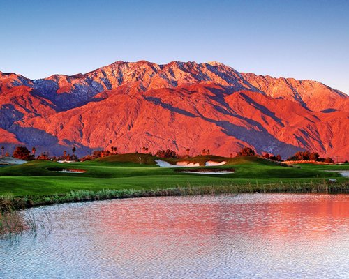 Golf course alongside the waterfront and mountain.