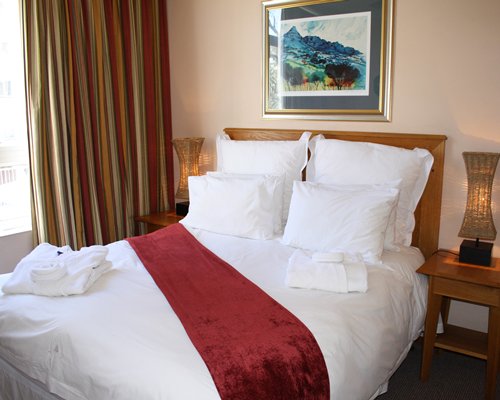 A well furnished bedroom with a queen bed and outside view.