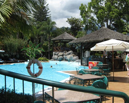 An outdoor swimming pool with a poolside bar and dining area.