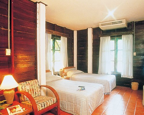 A well furnished bedroom with two twin beds and outside view.