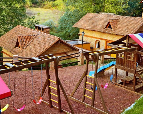 An outdoor playscape with swings alongside resort units.