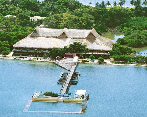 Exterior view of Isla Palma Superdecameron with marina surrounded by sea and wooded area.