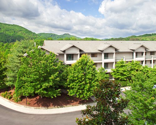 A street view of multi story resort units surrounded by trees.