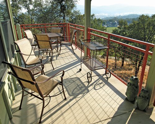 A balcony with patio furniture and a view of trees.