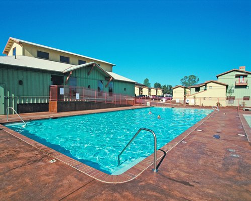A view of an outdoor swimming pool alongside resort units.